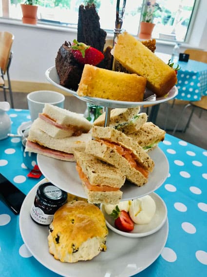 Cake stand full of cakes and sandwiches